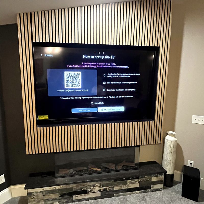 TV installed in a slat wall above a fireplace
